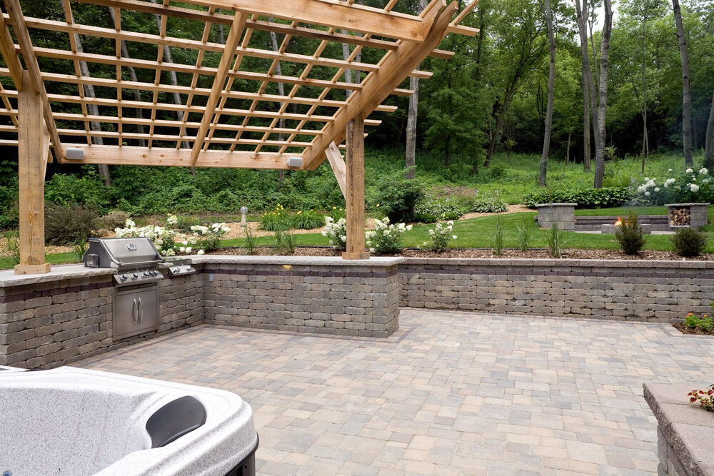 A beautiful paver patio, outdoor kitchen with built-in grill and pergola.