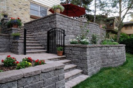 Retainig walls and pavers created a stunning deck alternative and create access to the back yard in this design.