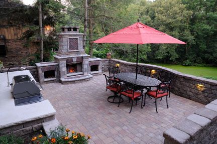 This raised patio created with retaining wall units and topped with a paver patio is a  low- to no-maintenance outdoor landscape design solution.