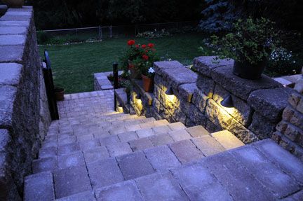 Steps with retaining walls and pavers, and stepped wing walls provide easy access to the yard.