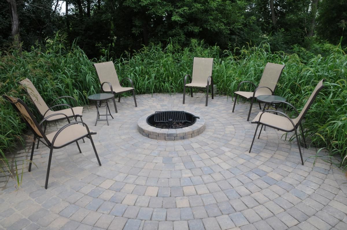 This patio and fire pit are beautifully framed in greenery