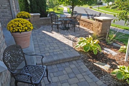 A patio and seating in front of a home creates a welcoming space for visitors and the homeowner. And it's eaxy to keep an eye on the neighborhood.