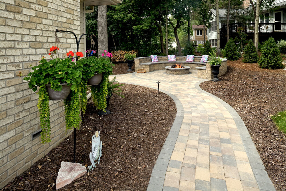Paver patio and walkway surrounded by natural mulch.