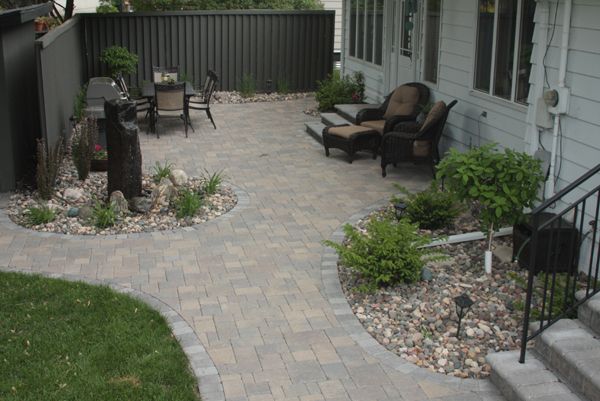 Willow Creek’s weathered Cobblestone pavers in Lakeshore Blend with a border course in a contrasting charcoal to create a sweeping, curving patio for entertaining plus a walkway to a storage shed