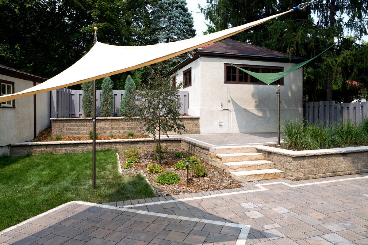 Raised patio with umbrellas, retaining wall steps and planters.