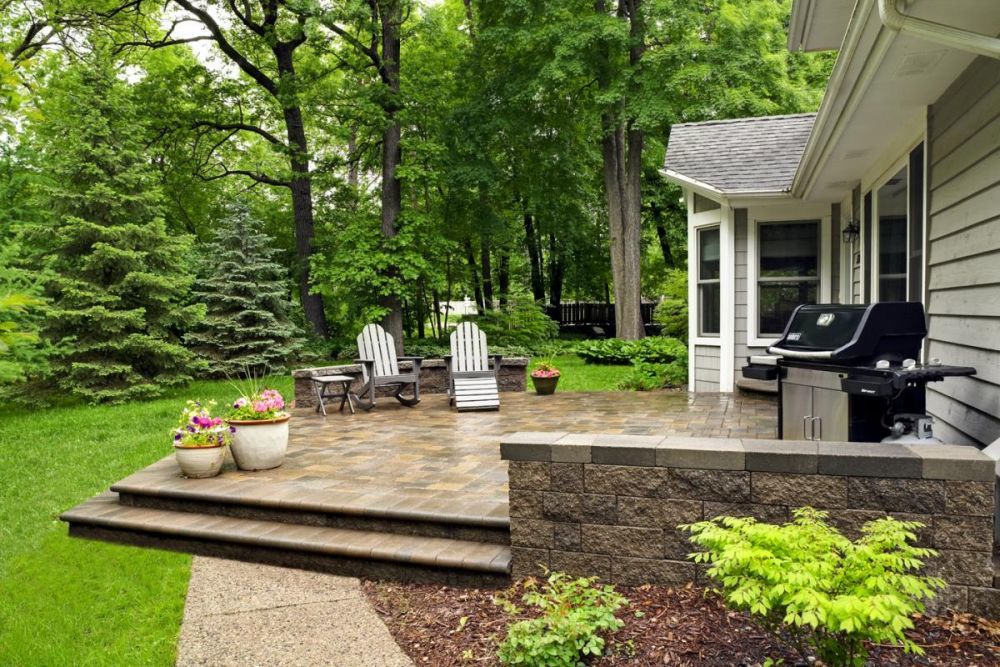 An inviting paver patio shows off hardscaping that extends this home into the out of doors.