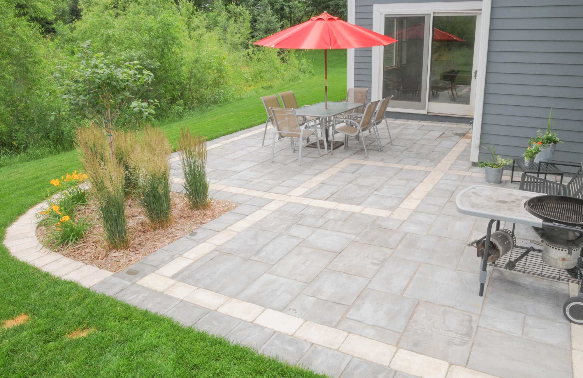 Pavers of a contrasting color neatly divide this large patio.