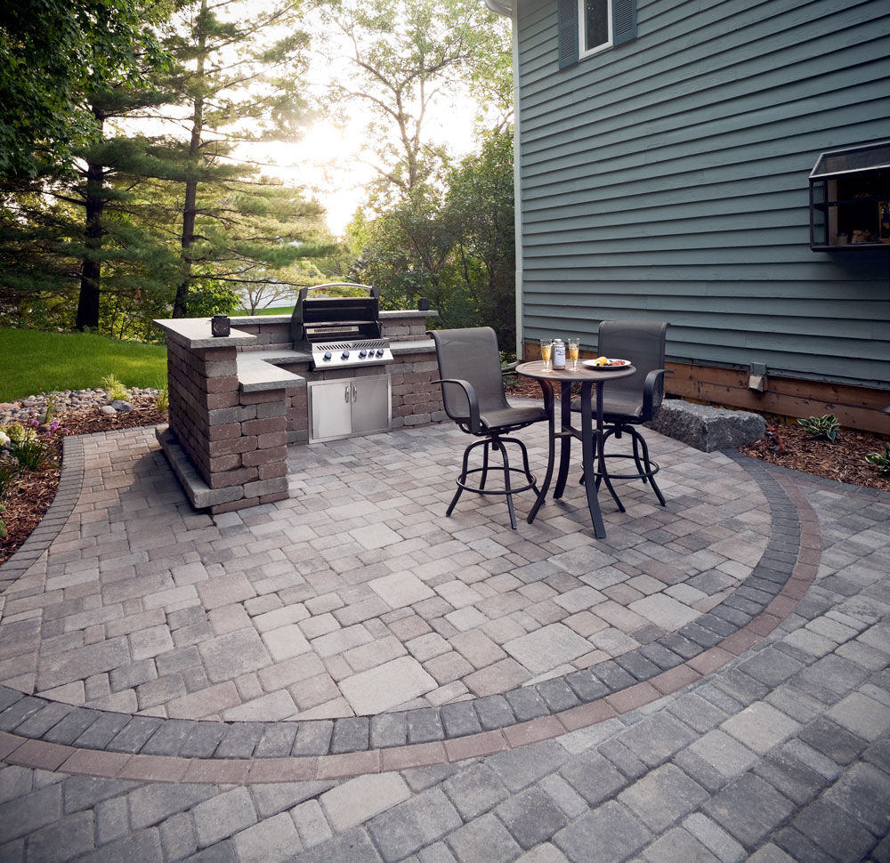 An outdoor bar and grill island from landscaping block makes evenings on the paving stone patio more enjoyable.