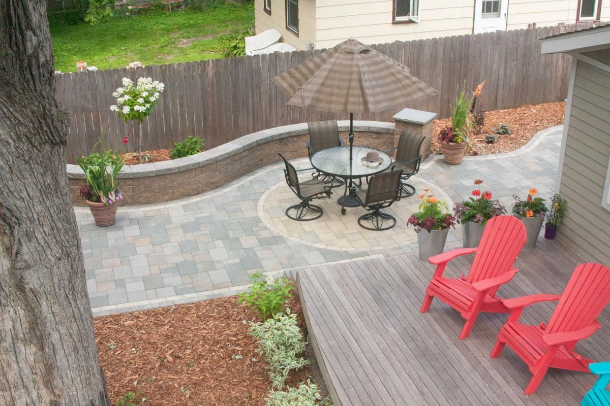 A permeable paver patio, seat wall and traditional deck create a sustainable and low maintenance outdoor living solution.