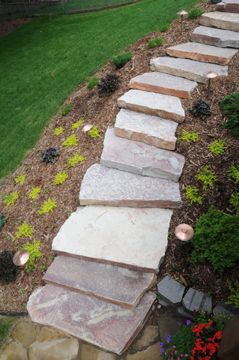 Natural stone stairs make for easy access to the top and bottom of this yard..