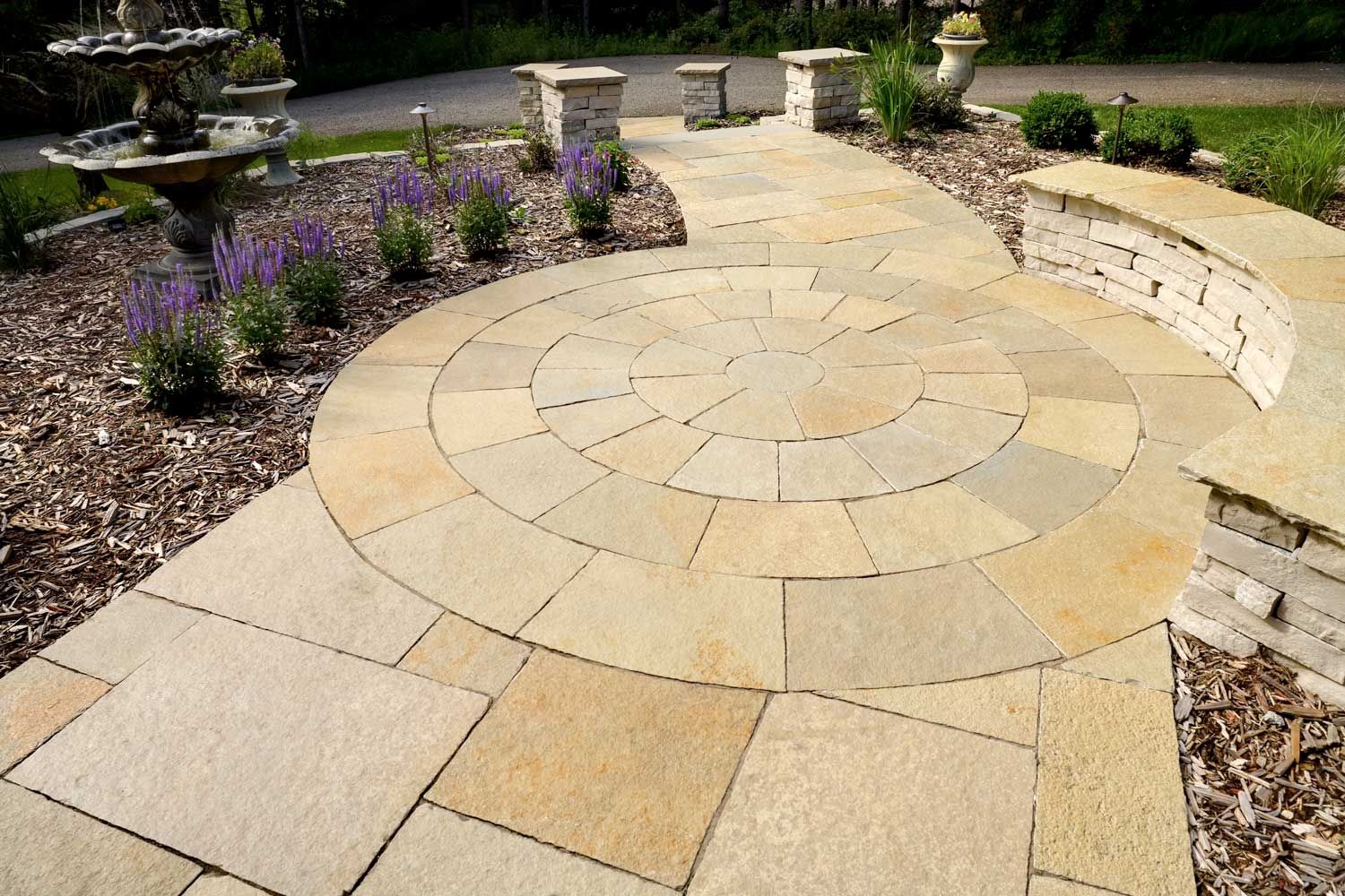 Natural Flagstone pavers create a walkway that leads to the street and patio with seat wall