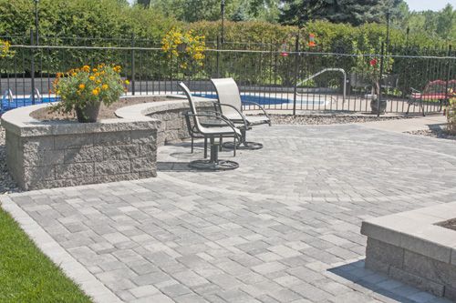 VERSA-LOK retaining walls make beautiful seat walls, planters and retaining walls and can easily incorporate curves, corners, columns and other features without the need for special units. The Willow Creek pavers look great bordered by natural rock and an iron fence, too.
